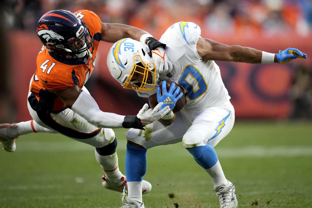 Broncos linebacker Kenny Young tackles Chargers running back Austin Ekeler.