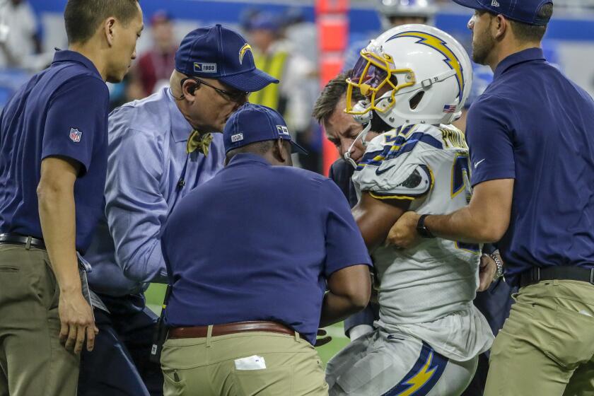 DETROIT, MICHIGAN, SUNDAY, SEPTEMBER 15, 2019 - Chargers safety Adrian Phillips is helped to his feet after suffering an injury late in the game against the Lions at Ford Field. (Robert Gauthier/Los Angeles Times)