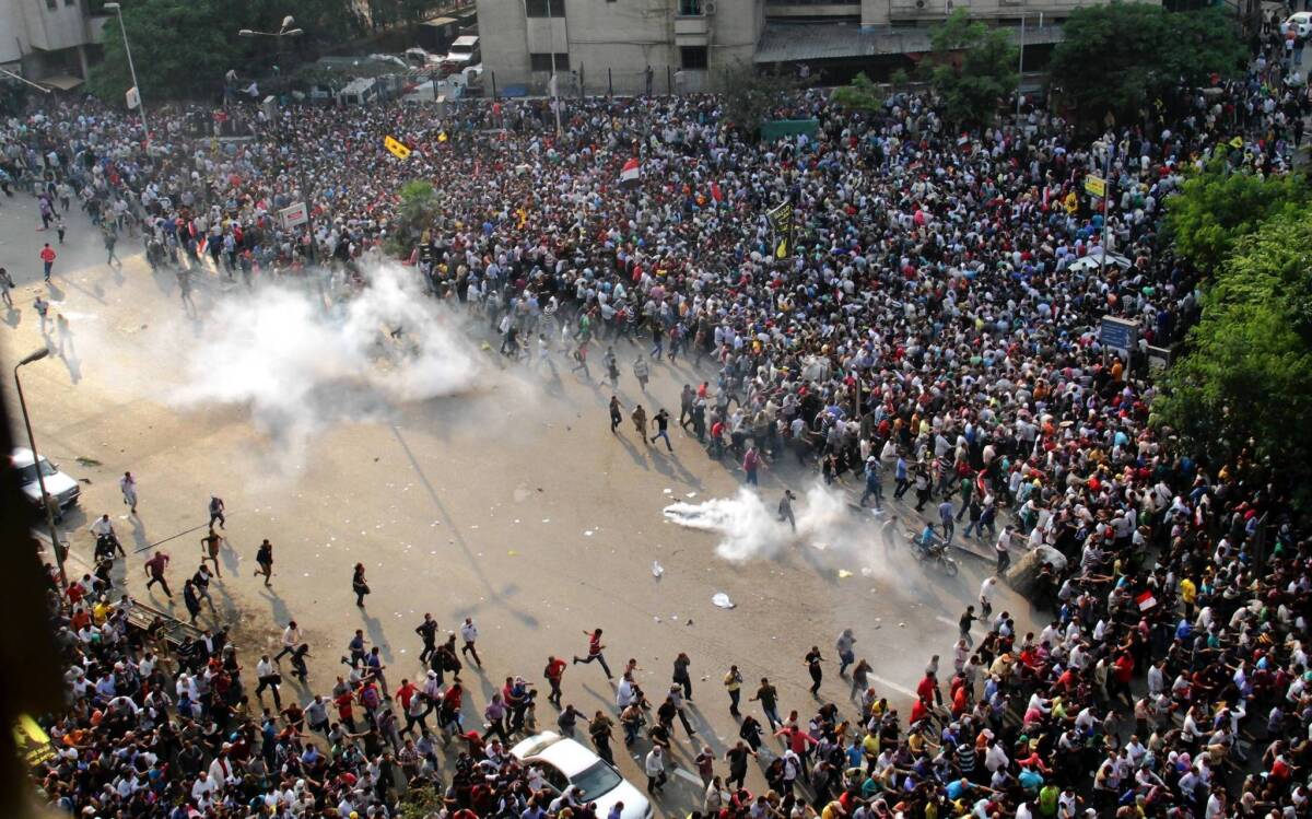 Supporters of ousted President Mohamed Morsi run for cover from tear gas during clashes with riot police in downtown Cairo.