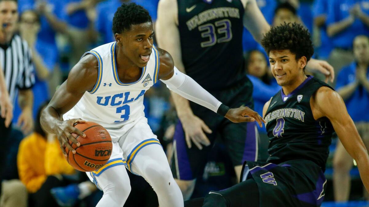 UCLA guard Aaron Holiday and Washington guard Matisse Thybulle in action.