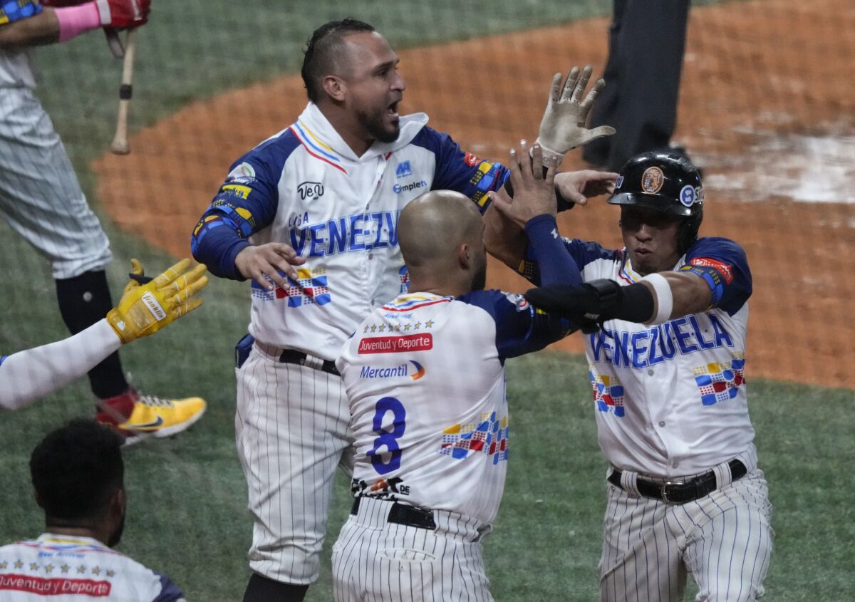 Wilfredo Tovar, de Venezuela, festeja con sus compañeros luego de anotar ante Cuba en la Serie del Caribe, el sábado 4 de febrero de 2023, en Caracas (AP Foto/Fernando Llano)