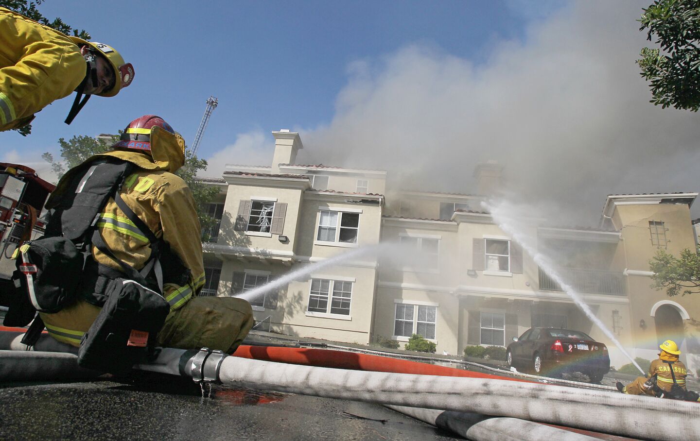 Firefighters pour water onto the Ambrosia apartment complex to keep flames from spreading to other structures.