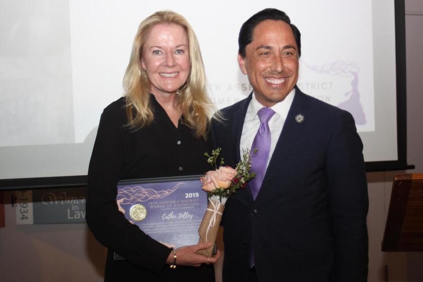 Pacific Beach resident Cathie Jolley receives a Woman of Distinction recognition from Assembly member Todd Gloria.