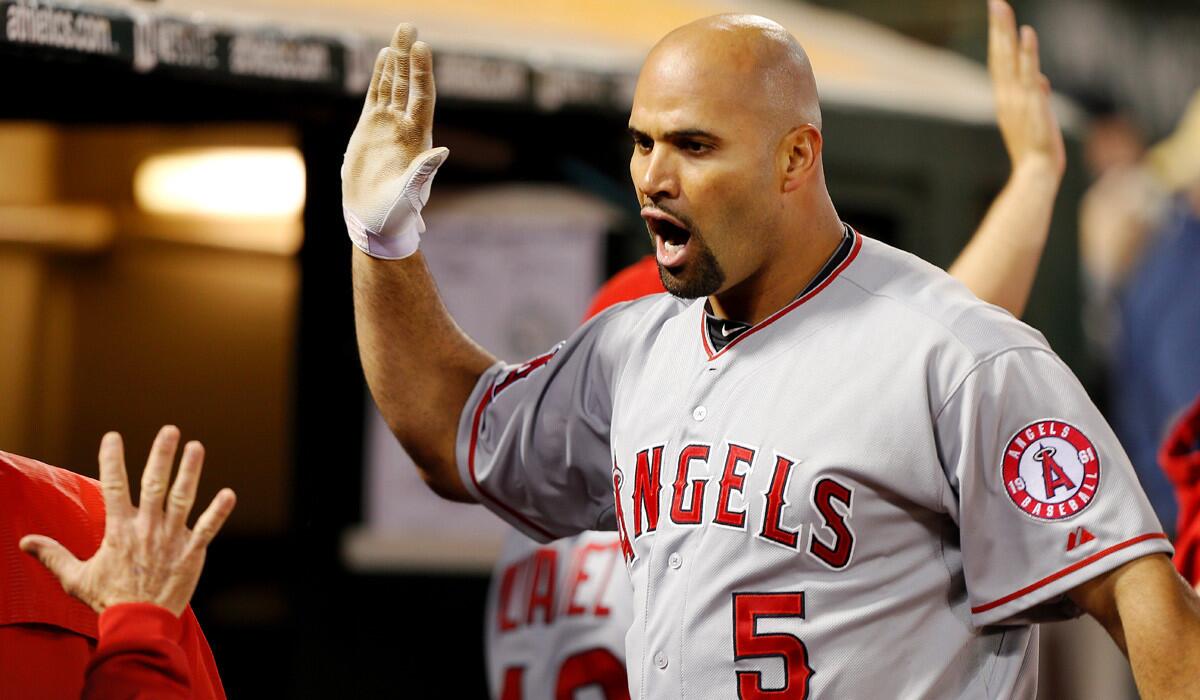 Albert Pujols celebrates after hitting a grand slam against the Oakland Athletics in the seventh inning on June 19.
