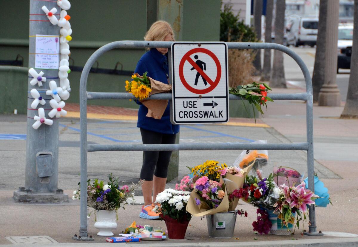 A woman stops to view the memorial of Rosenda Elizabeth Smiley, 14, killed Saturday near Balboa Boulevard and Palm Street.