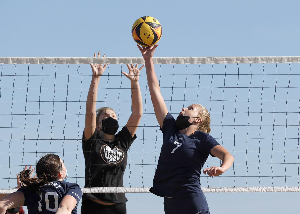 Newport Harbor's Deven Pence (7) tips one over the net for point during a beach volleyball match against Huntington Beach.