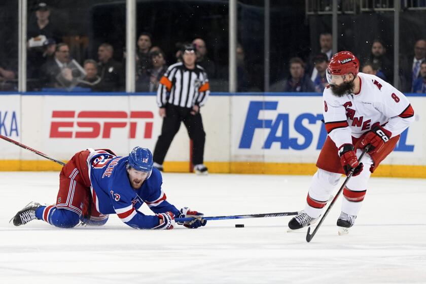 New York Rangers left wing Alexis Lafrenière (13) and Carolina Hurricanes defenseman Brent Burns (8) vie for the puck during the second period in Game 2 of an NHL hockey Stanley Cup second-round playoff series Tuesday, May 7, 2024, in New York. (AP Photo/Julia Nikhinson)