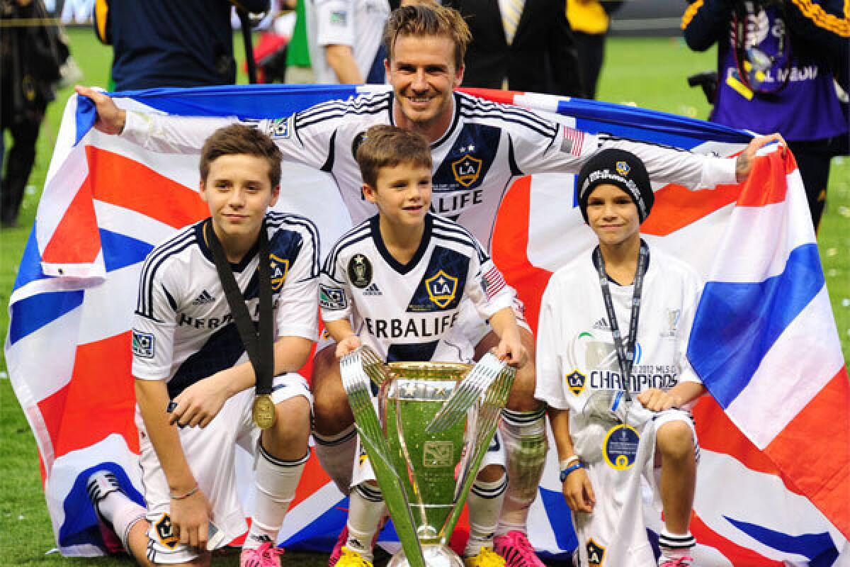 David Beckham poses with sons Brooklyn, left, Cruz and Romeo after the Galaxy claimed the MLS Cup in December.