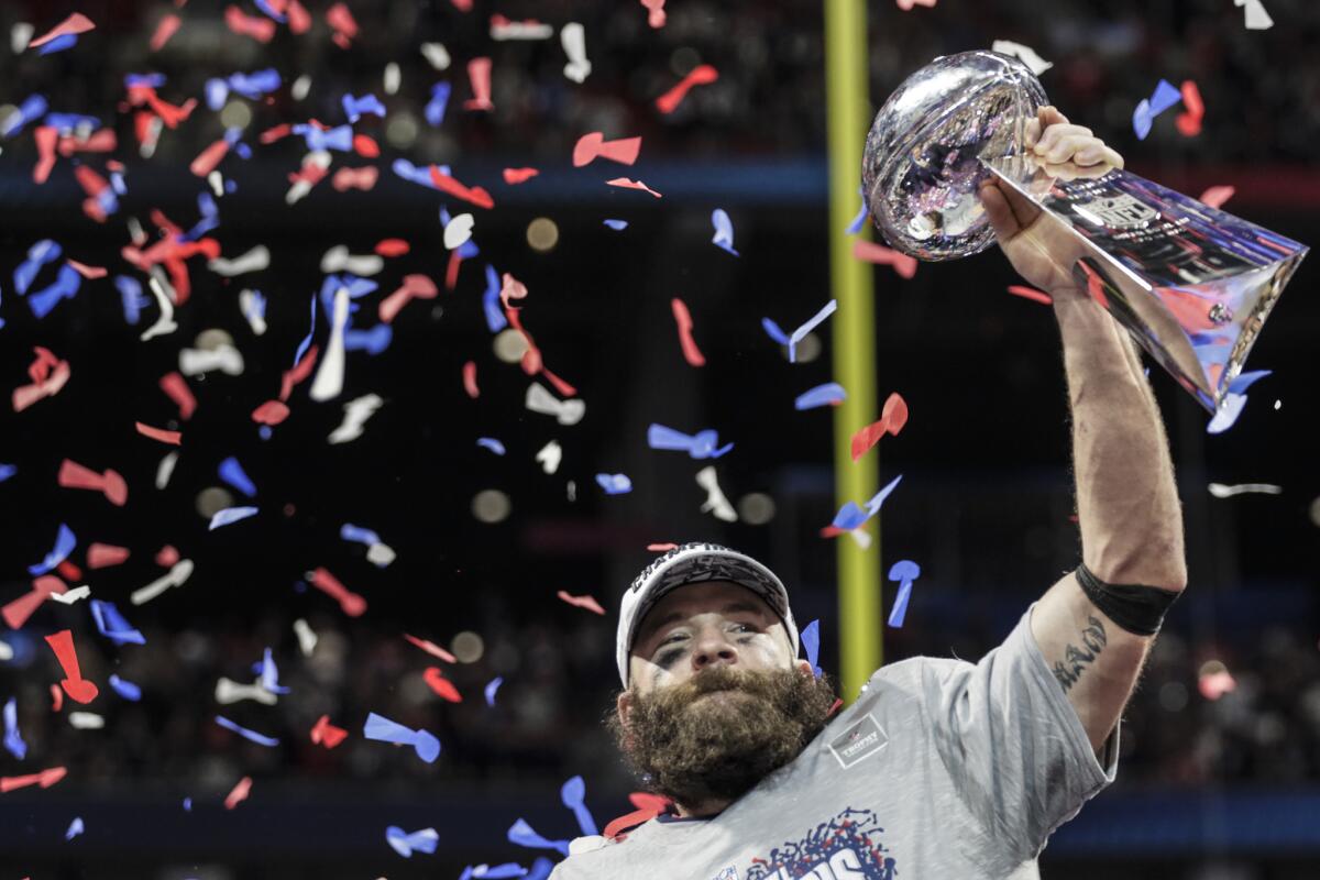 Super Bowl MVP Julian Edelman hoists the Vince Lombardi Trophy after New England beat the Rams 13-3 on Sunday at Mercedes-Benz Stadium.