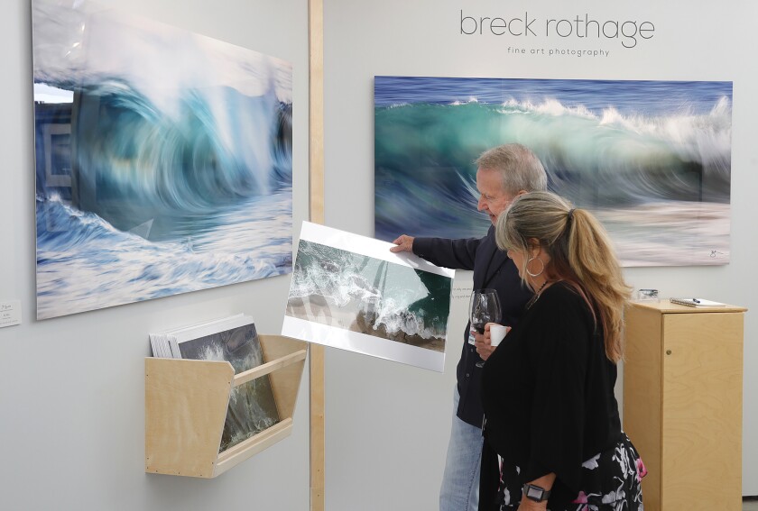 Guests view the work of Breck Rothage at the Festival of Arts opening reception in Laguna Beach on Saturday.