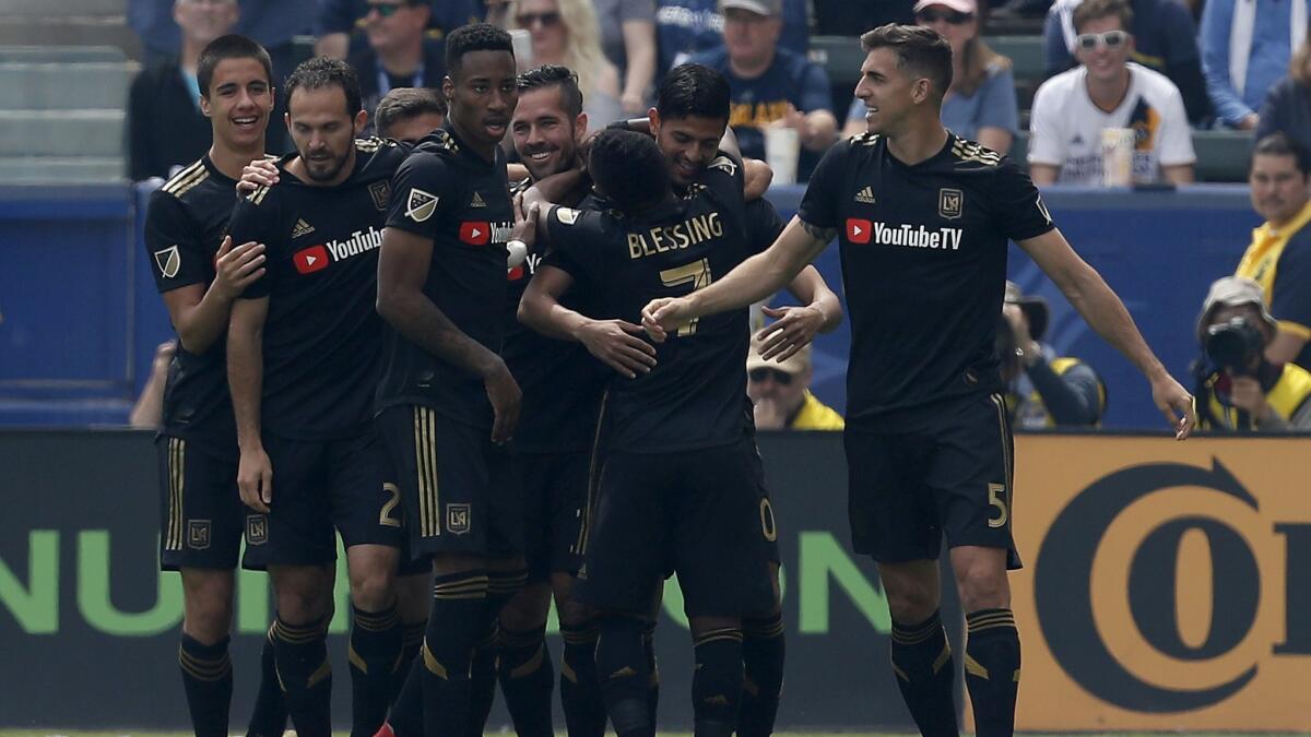 LAFC forward Carlos Vela, second from right, is congratulated by teammates after scoring the first of his two first-half goals against the Galaxy on Mar. 31, 2018 in Carson.