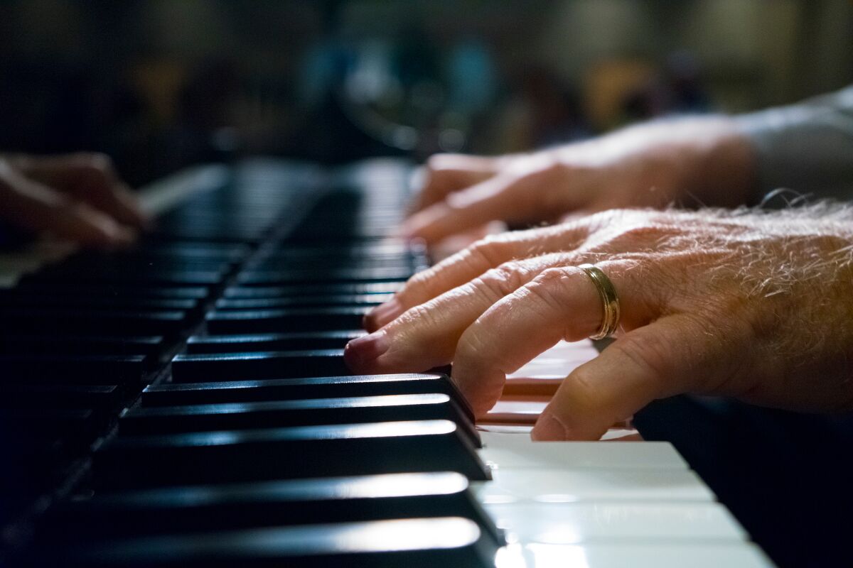 A closeup of hands playing piano
