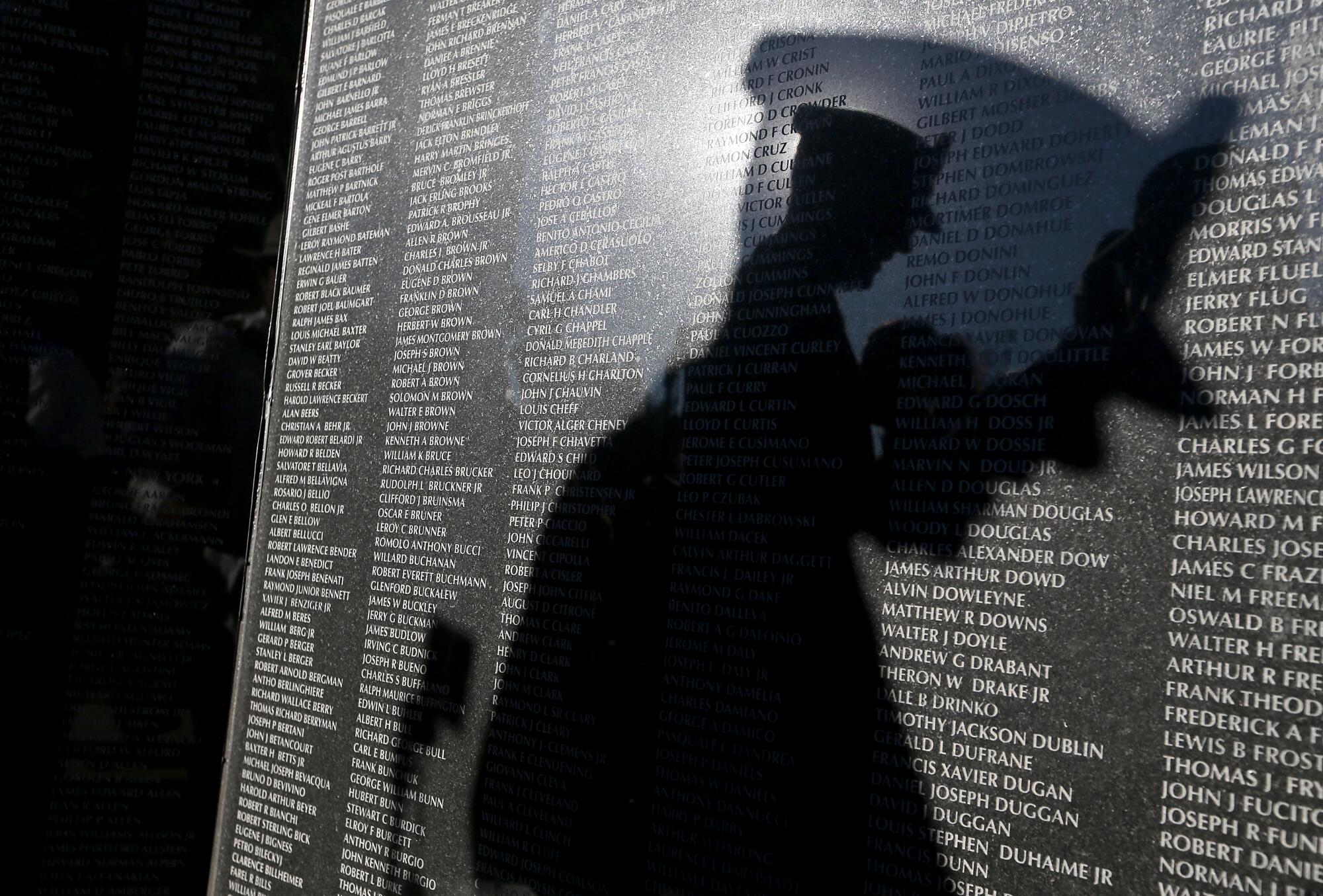 The shadow of Army Brig. Gen. Robert Wooldridge falls on a Korean War memorial.