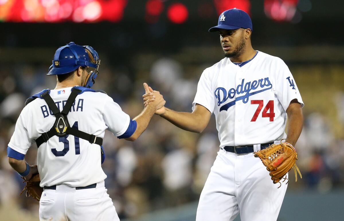 Drew Butera, left, and Kenley Jansen, right, celebrate the Dodgers' 6-3 win Tuesday over the Reds at Dodger Stadium.