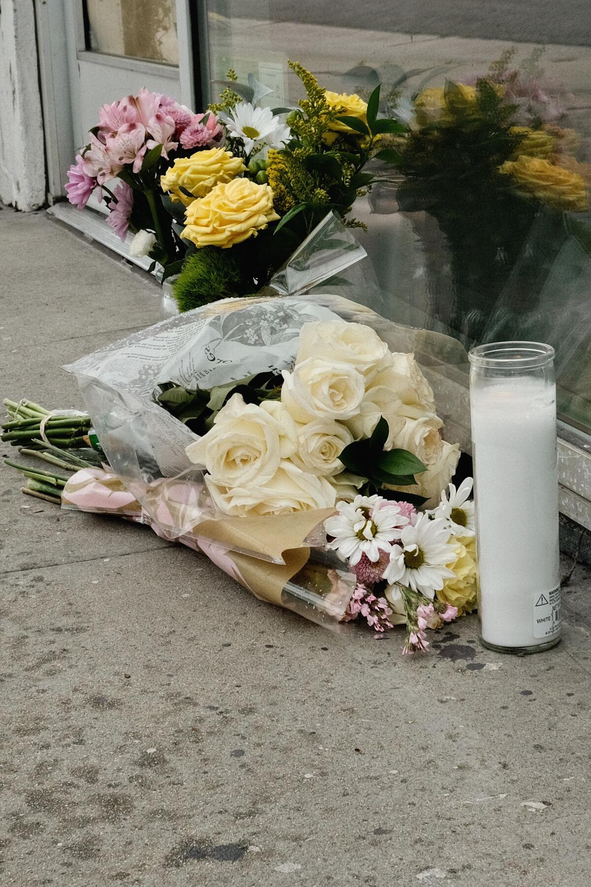 A vertical closeup of a small memorial of flowers and white 