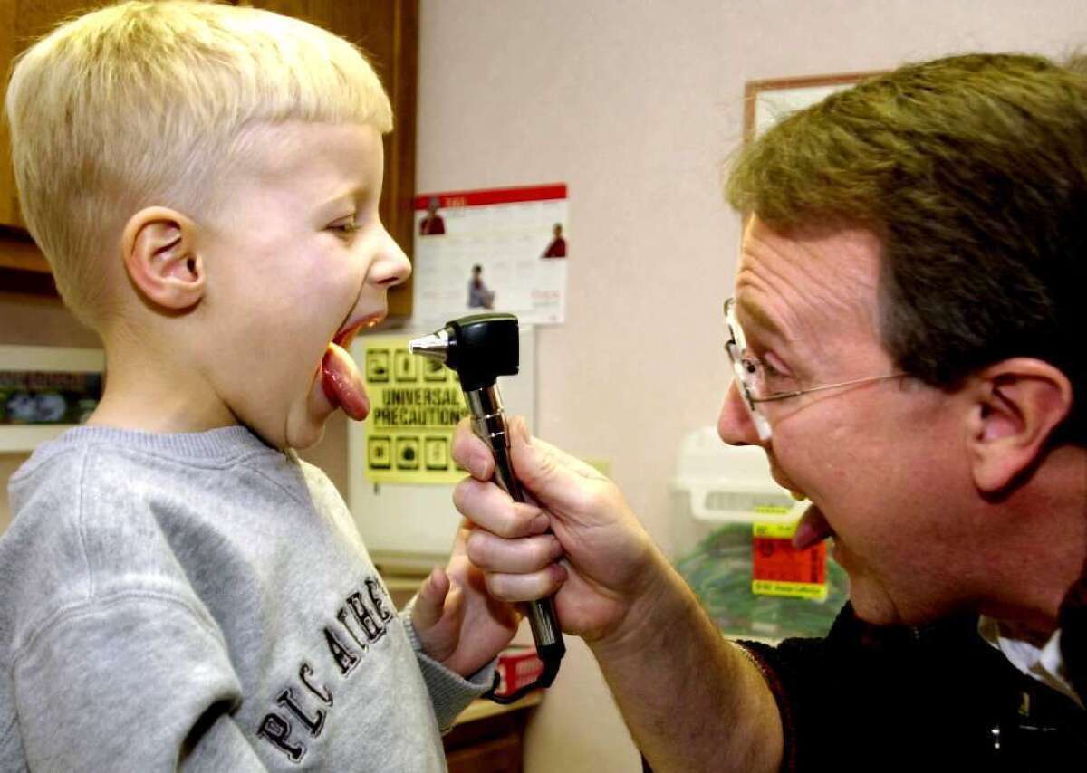 Four-year-old Cameron Pack, of Cool Ridge, W. Va., gets that "aaaah" treatment from Dr. James H. Blume. The Affordable Care Act, enacted eight years after this picture was taken, lets more families into the healthcare insurance market.