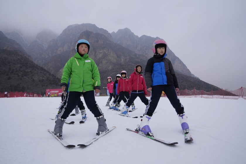 School children learning to ski take to the slope at the Vanke Shijinglong Ski Resort in Yanqing on the outskirts of Beijing, China, Thursday, Dec. 23, 2021. The Beijing Winter Olympics is tapping into and encouraging growing interest among Chinese in skiing, skating, hockey and other previously unfamiliar winter sports. It's also creating new business opportunities. (AP Photo/Ng Han Guan)