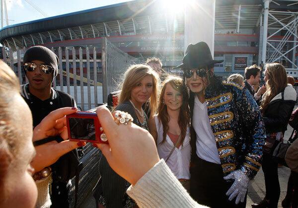 A Michael Jackson look-alike poses with fans as they gather for the 'Michael Forever' tribute concert.