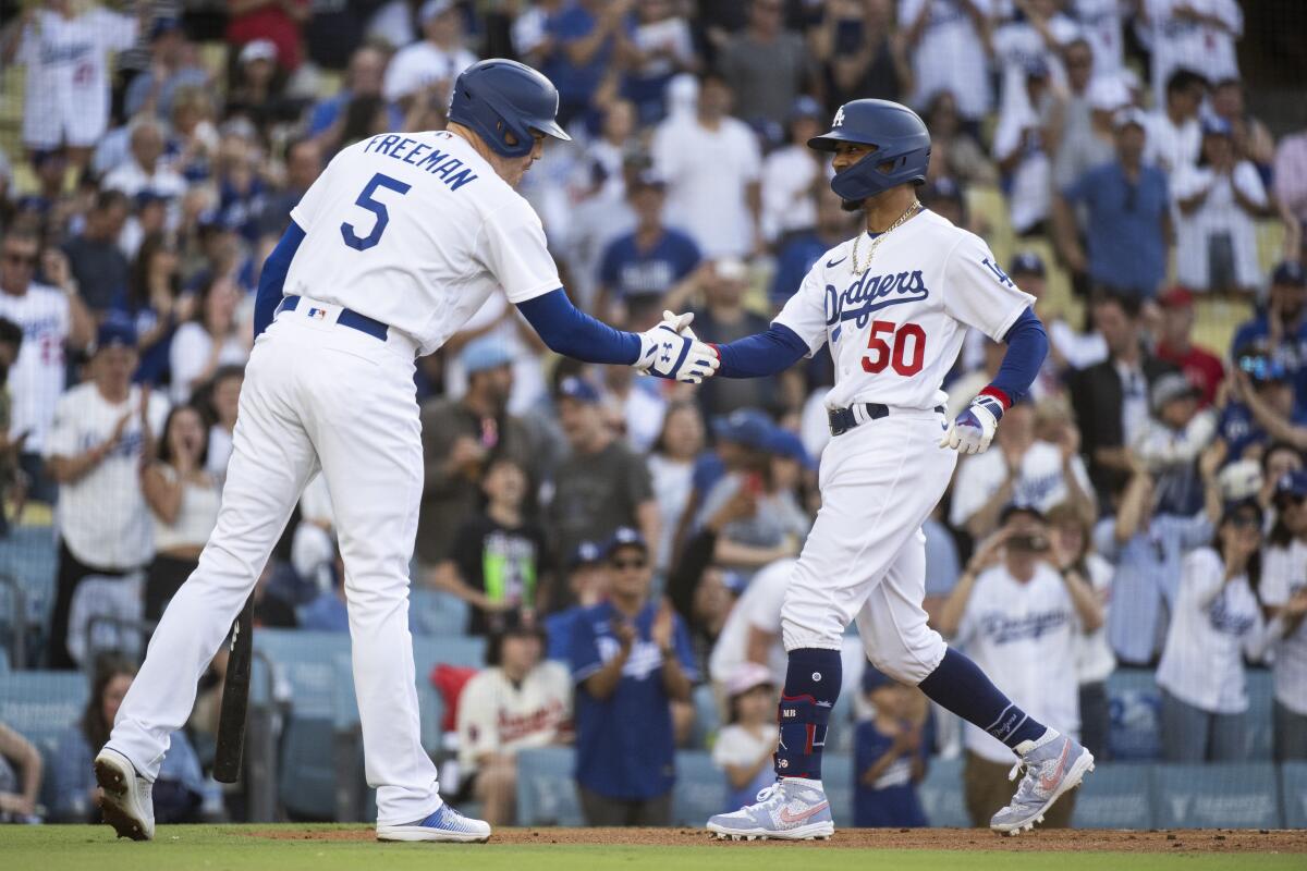 Dodgers' Mookie Betts celebrates with Freddie Freeman after hitting a home run on July 8, 2023, against the Angels.