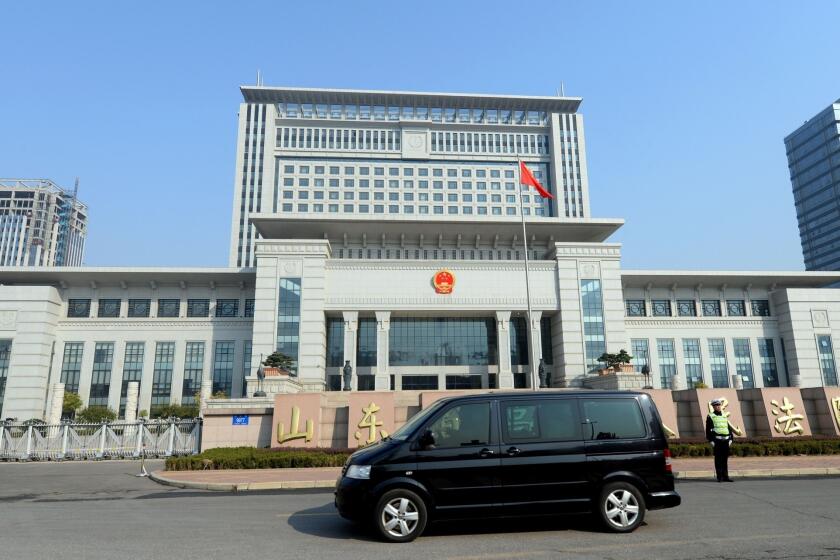 A vehicle believed to be ferrying once-powerful politician Bo Xilai arrives at the Shandong high court building in Jinan, in eastern China's Shandong province, on Friday.