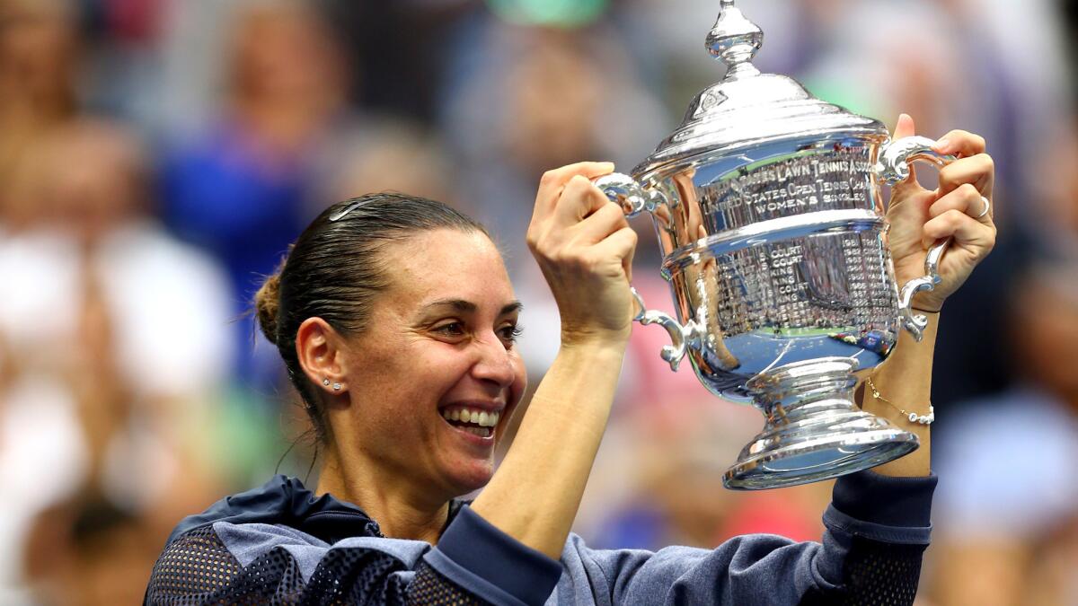 Flavia Pennetta hoists the winner's trophy after defeating fellow Italian Roberta Vinci for the U.S. Open title.