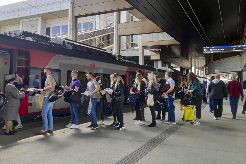 FILE - Passengers at a railway station in Minsk, Belarus, stand in line to board a high-speed train to Moscow on May 28, 2021. A Belarusian hacktivist group says it has launched a limited cyberattack on the national railway company, aimed at impeding the movement of Russian troops and freight inside the Moscow-allied country. (AP Photo)