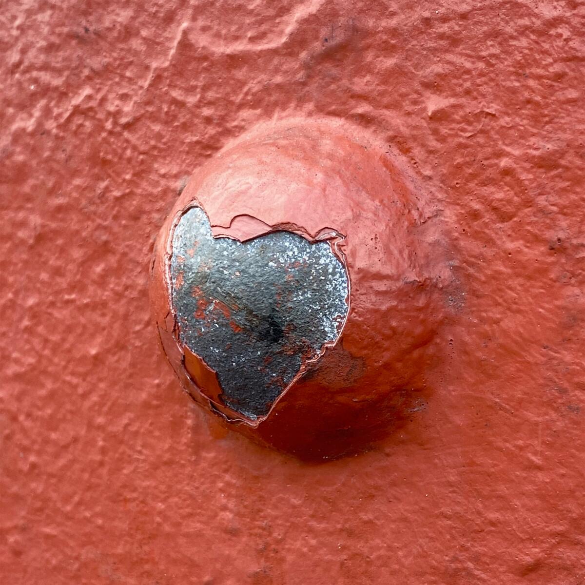 Paint is chipped away in the shape of a heart on one of the rivets of the Golden Gate Bridge.