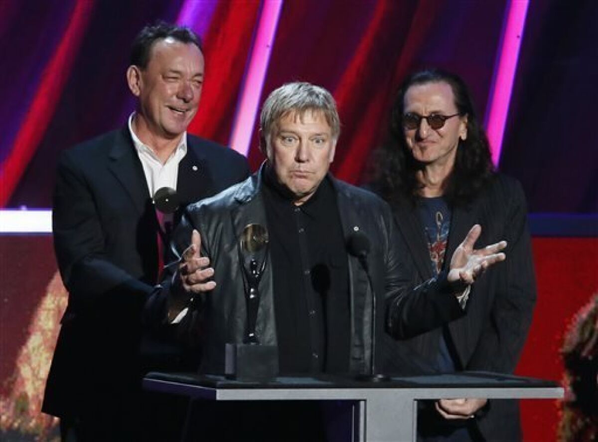 Neil Peart, left, Alex Lifeson, center, and Geddy Lee of Rush accept their band's induction into the Rock and Roll Hall of Fame during the Rock and Roll Hall of Fame Induction Ceremony at the Nokia Theatre on Thursday, April 18, 2013 in Los Angeles. Peart died on Tuesday, Jan.7, after a three-and-a-half-year battle with brain cancer. He was 67.