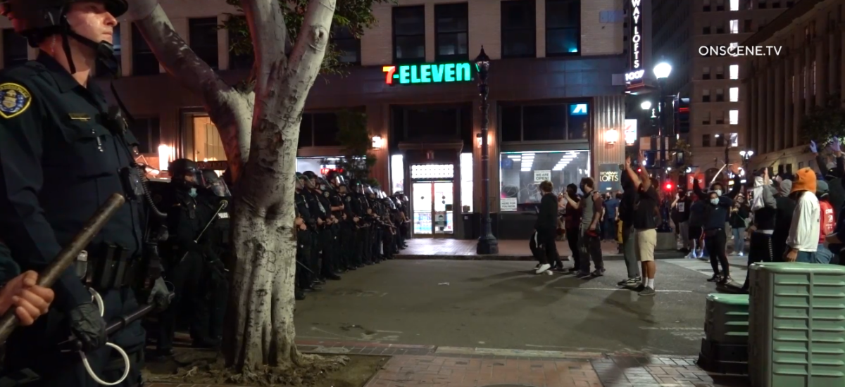 Police face a crowd of protesters in downtown San Diego late Sunday evening. 