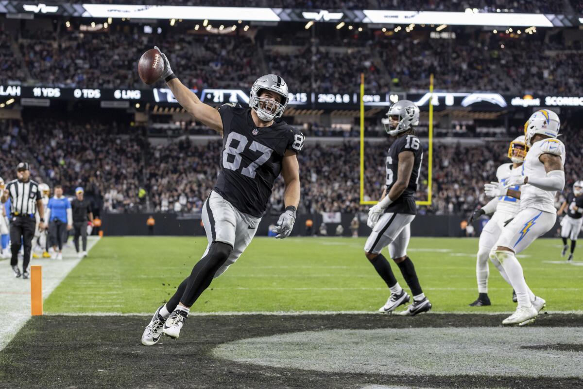 Raiders tight end Michael Mayer holds up the ball after his touchdown catch against the Chargers.