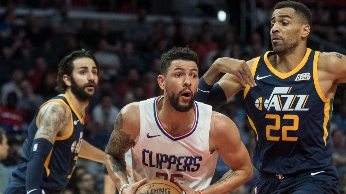 Clippers guard Austin Rivers, center, drives past Utah Jazz guard Ricky Rubio, left, and forward Thabo Sefolosha during the second half on Tuesday.