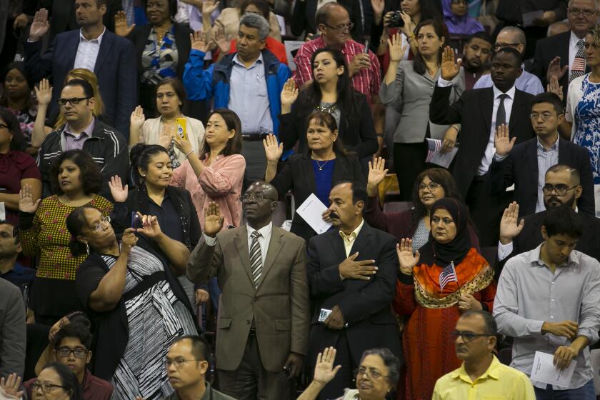 Immigrants raise their hands as they take the oath during a naturalization ceremony at the M.O. Campbell Education Center on Saturday, Sept. 18, 2019, in north Houston.