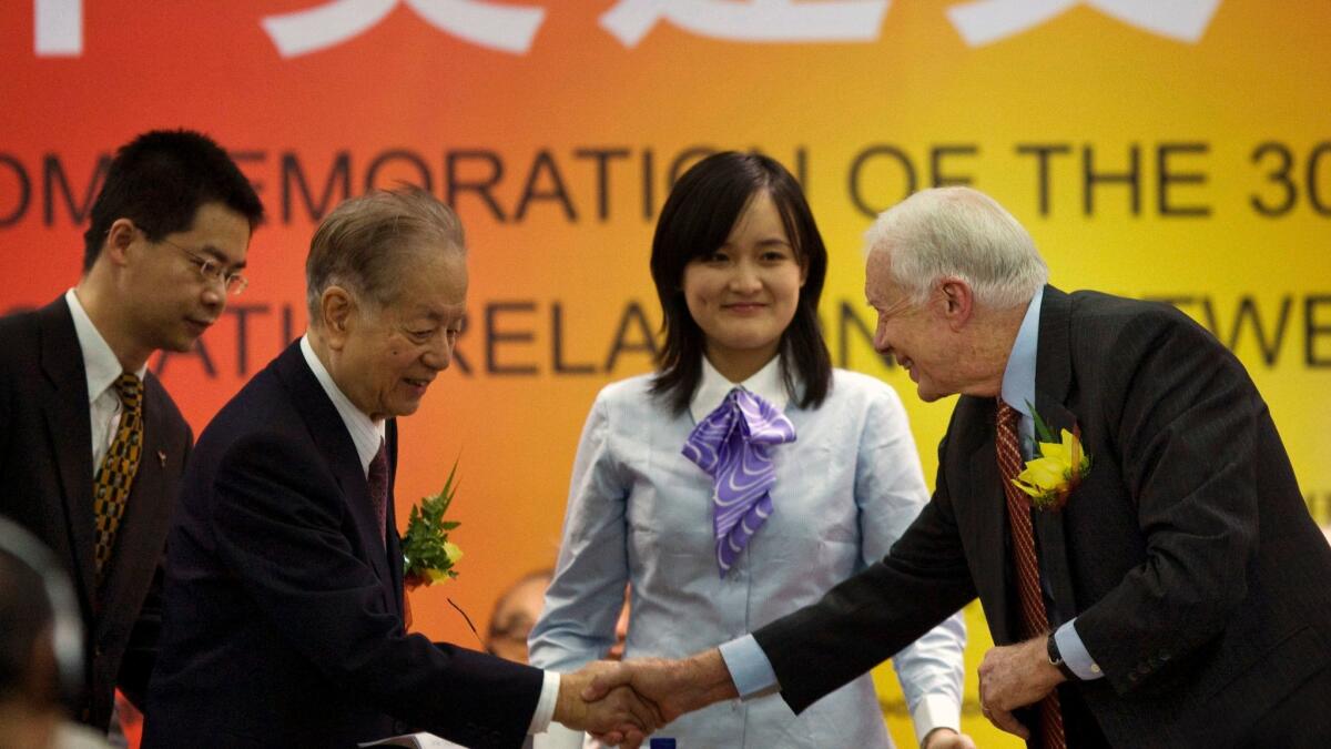 Chinese Vice Premier Qian Qichen shakes hands with President Carter in Beijing in 2009.