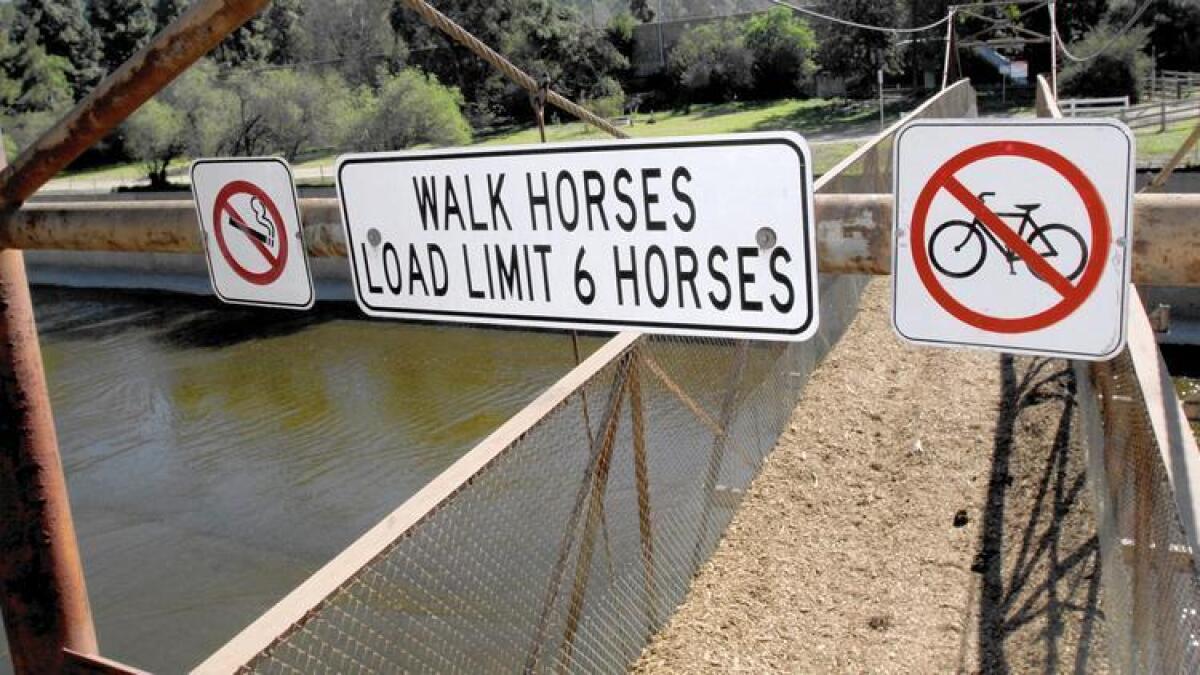 Signs stating the user rules of the Mariposa Street Bridge are posted at the top of the bridge.