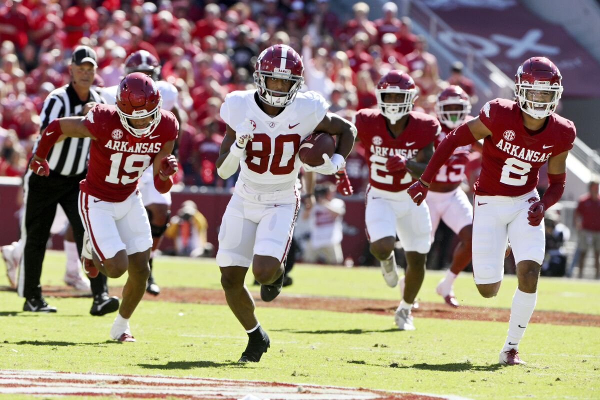 Alabama receiver Kobe Prentice (80) breaks away from Arkansas defenders, Khari Johnson (19), Chris Paul Jr. (27) and Myles Slusher (2) on his way to score a touchdown during the first half of an NCAA college football game Saturday, Oct. 1, 2022, in Fayetteville, Ark. (AP Photo/Michael Woods)