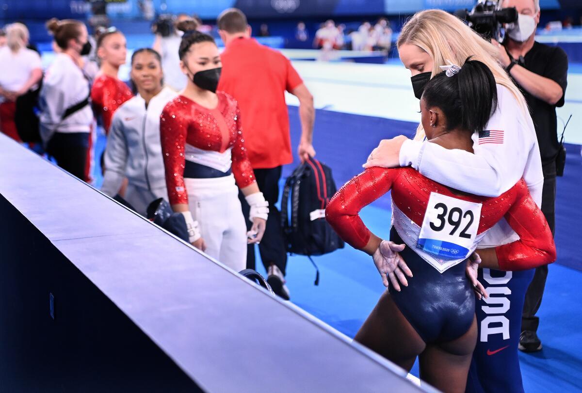 Simone Biles is consoled after withdrawing from Olympic competition. 