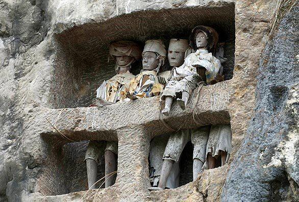 At Suaya cliff on Indonesia's Sulawesi island, life-size wooden dolls, representing dead Torajan royals entombed there, look down on family members who regularly deliver offerings such as cigarettes, palm wine and bottled water.