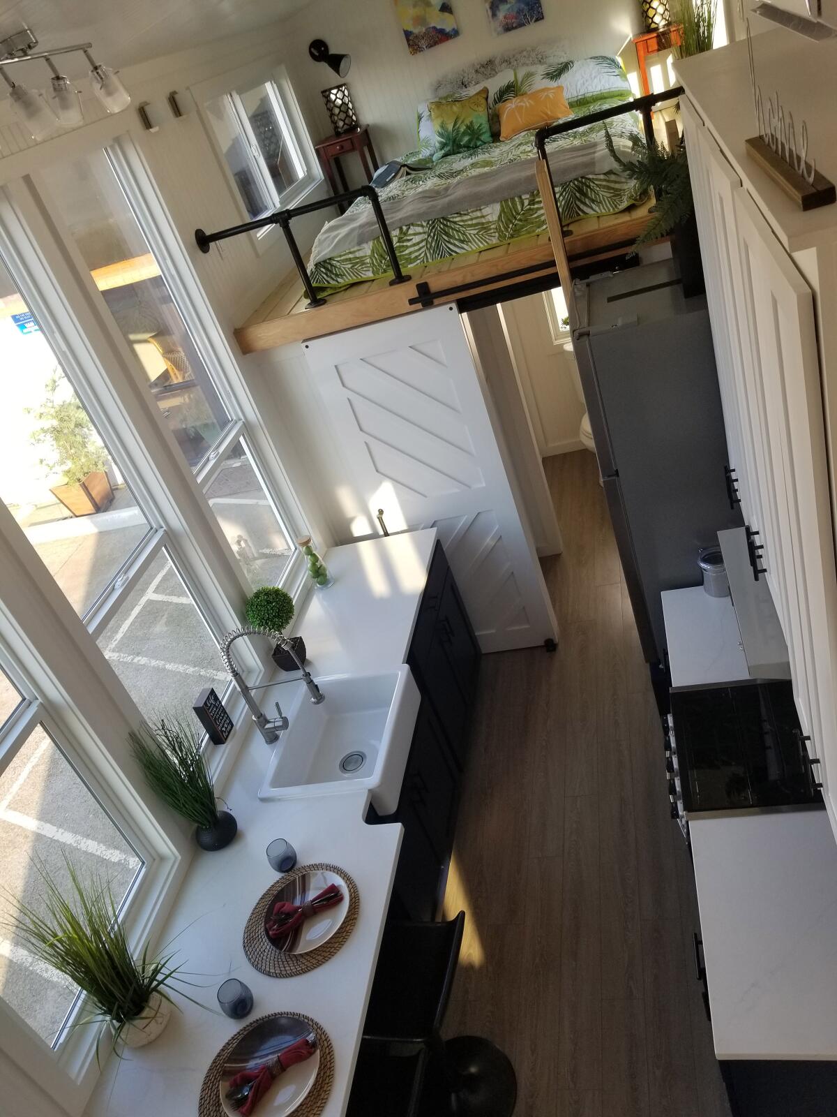 High ceilings, big windows and a loft bedroom show modern farmhouse flair in this spacious model from Tiny Mountain Houses.