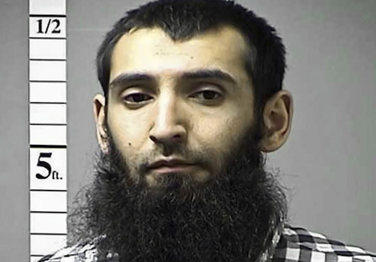 A man with a full beard looks into the camera during a law enforcement photograph. 
