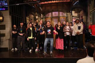 A large group of people gathered on a stage in a TV studio