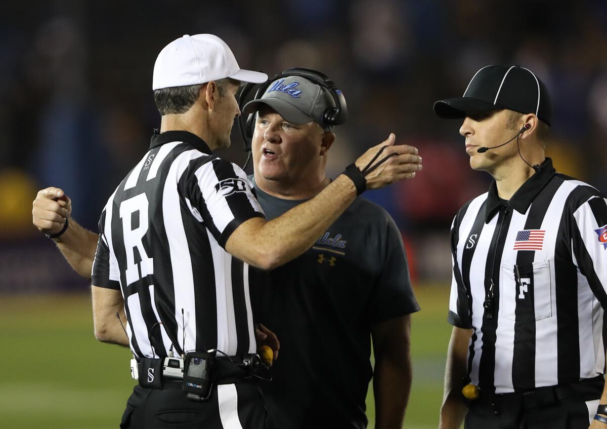 UCLA coach Chip Kelly speaks with game officials during the Bruins' win over Arizona State on Saturday.