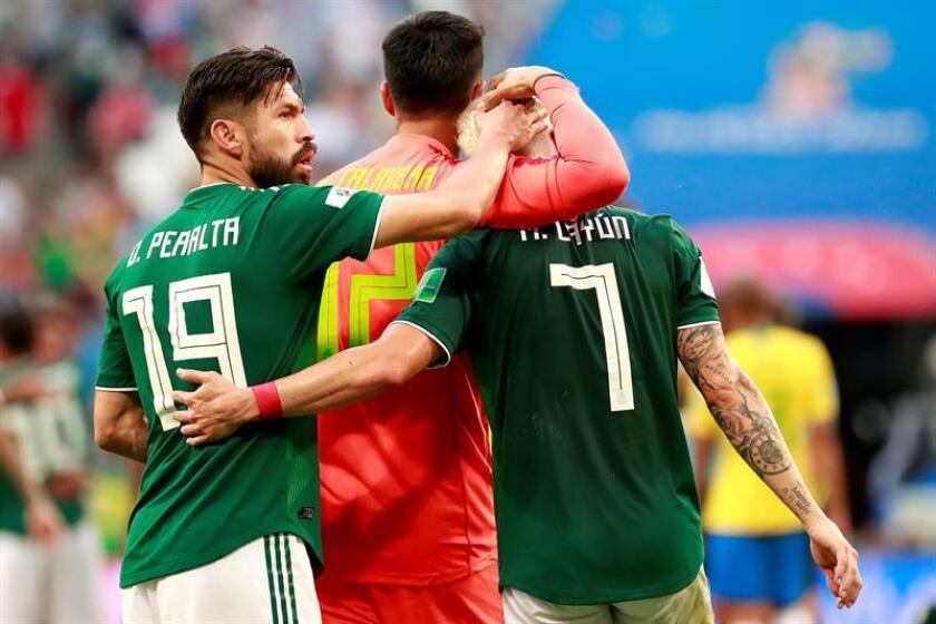 El delantero mexicano Oribe Peralta (i) y el defensa mexicano Miguel Layún (d) reaccionan tras el partido Brasil-México, de octavos de final del Mundial de Fútbol de Rusia 2018, en el Samara Arena de Samara, Rusia, ayer. EFE