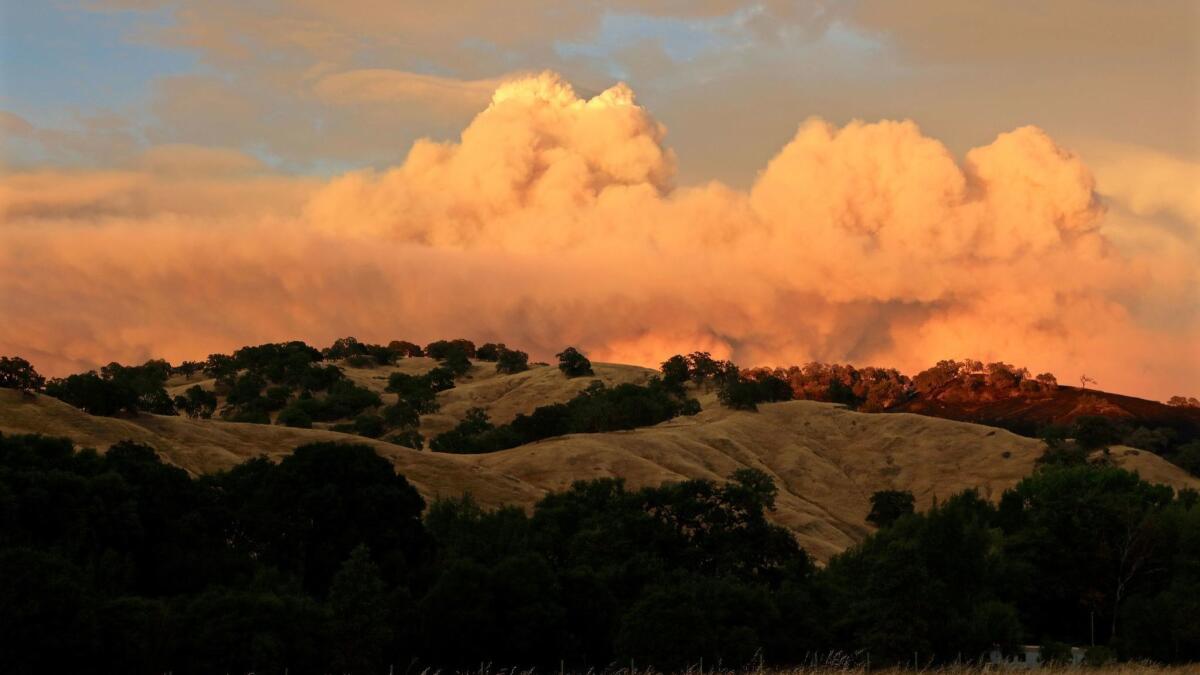 Sunset strikes the smoke clouds from the Ranch fire portion of the Mendocino complex fires near the Mendocino National Forest on Sunday.