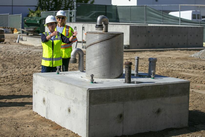 Karyn Igar, left, a senior civil engineer and Marice DePasquale, the Mesa Water District board president, talk about one of two new potable water wells in the city of Costa Mesa on Monday, November 8.