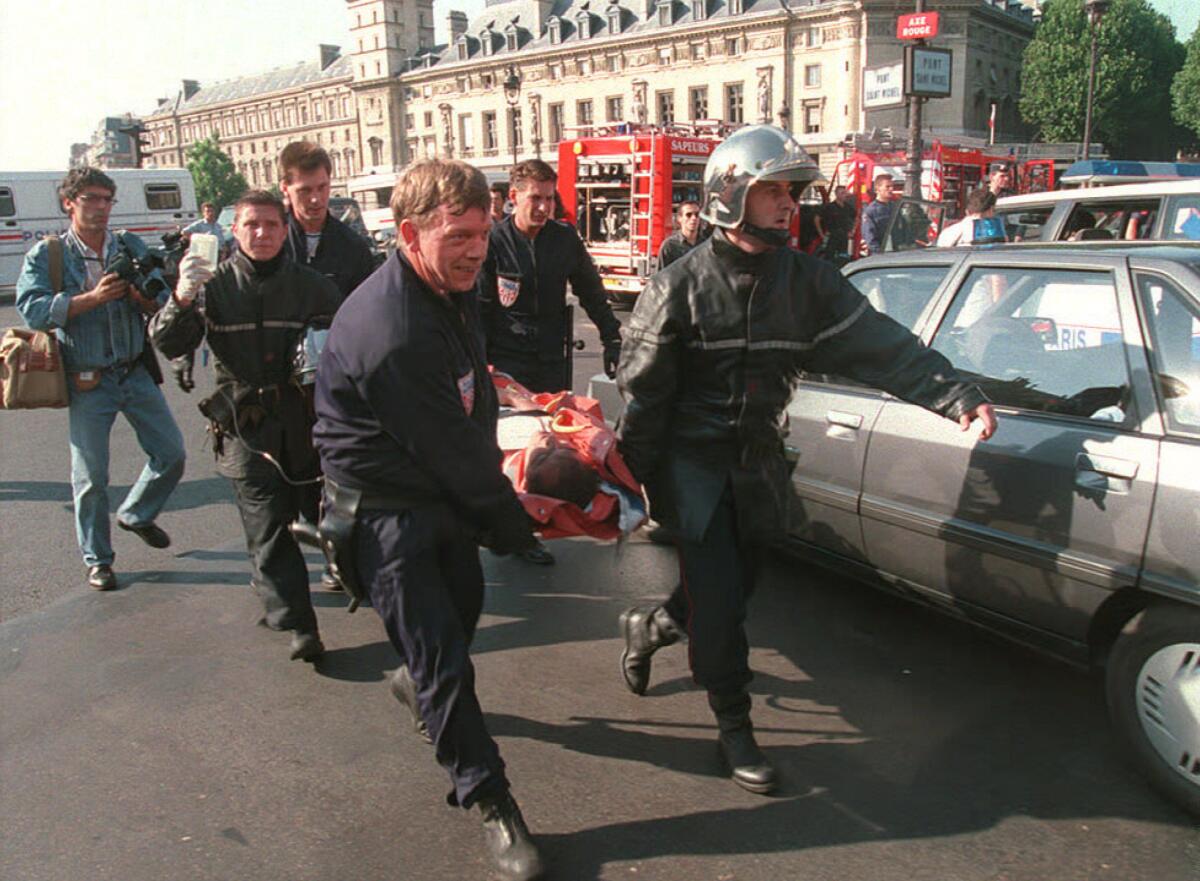 Rescuers race to evacuate one of the dozens of commuters who were injured when a bomb exploded in a subway train during rush hour inside the crowded Saint-Michel station along the Seine in Paris on July 25, 1995.