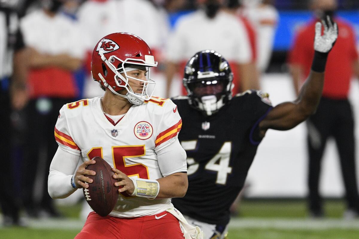 Kansas City Chiefs quarterback Patrick Mahomes looks to pass under pressure from Baltimore Ravens linebacker Tyus Bowser.