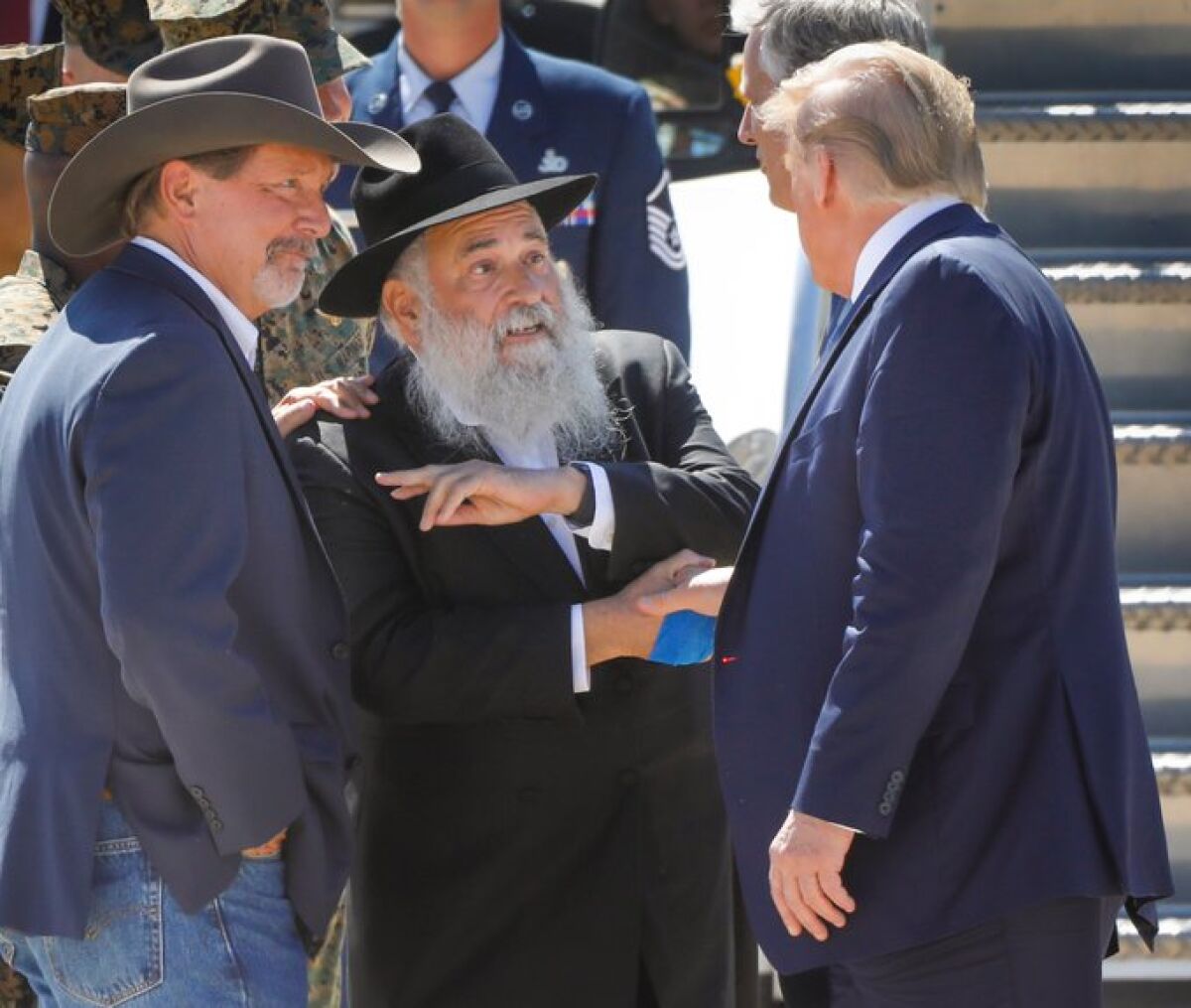 President Donald Trump is greeted by Poway Mayor Steve Vaus, and Rabbi Yisroel Goldstein, of Chabad of Poway, upon arriving MCAS Miramar for a San Diego visit. The rabbi was shot by a gunman who attacked the congregation in April.