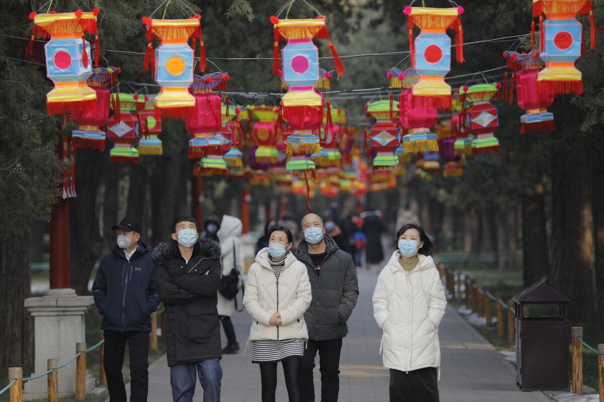 People wear masks in Jingshan Park in Beijing. Beijing canceled many Spring Festival celebrations because of the coronavirus outbreak.