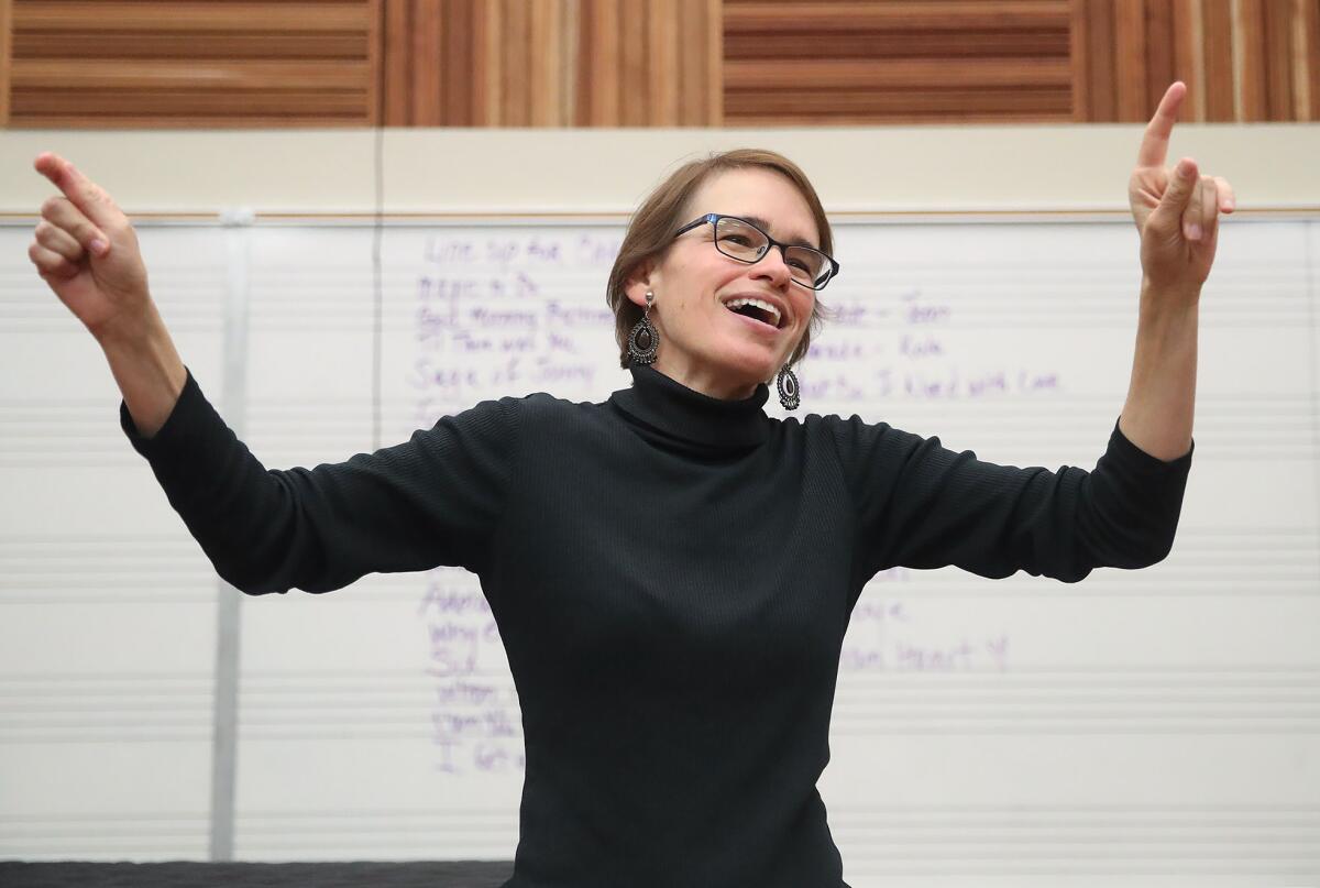 Orange Coast College conductor Eliza Rubenstein leads students in a warm up Friday.