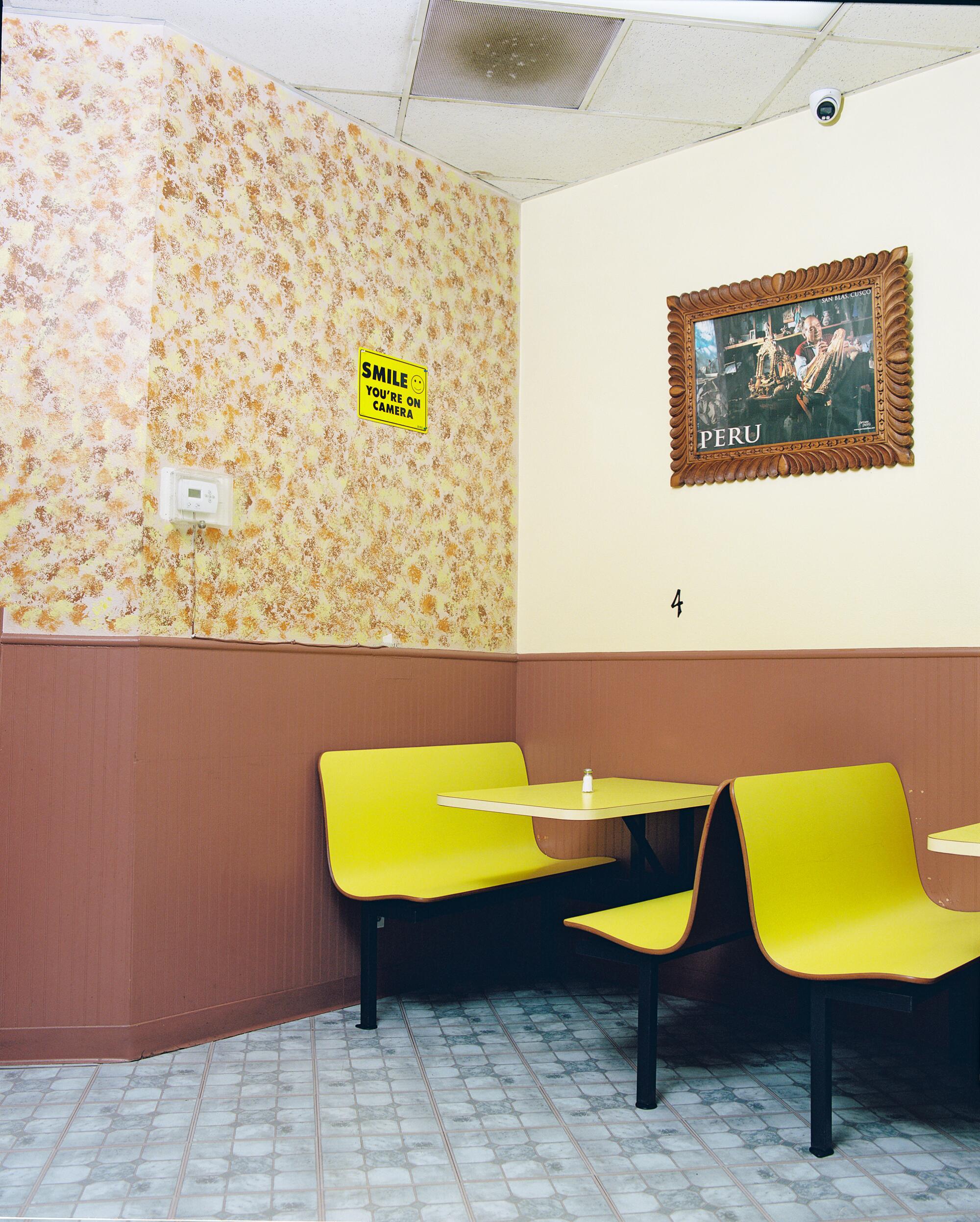 A photo of yellow booths and yellow tables at a Peruvian restaurant.